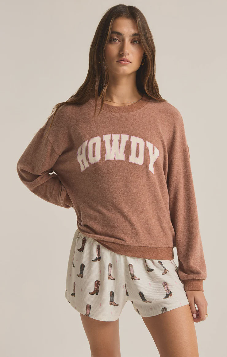 Featuring a soft crew neck long sleeve with the logo "Howdy" in the color maple heather 