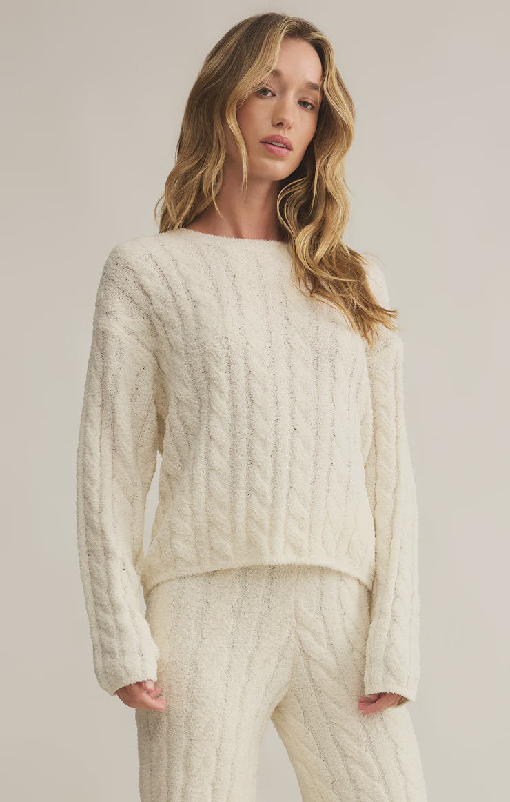 Featuring a cozy and soft long sleeve crew neck cable knit sweater in the color sea salt