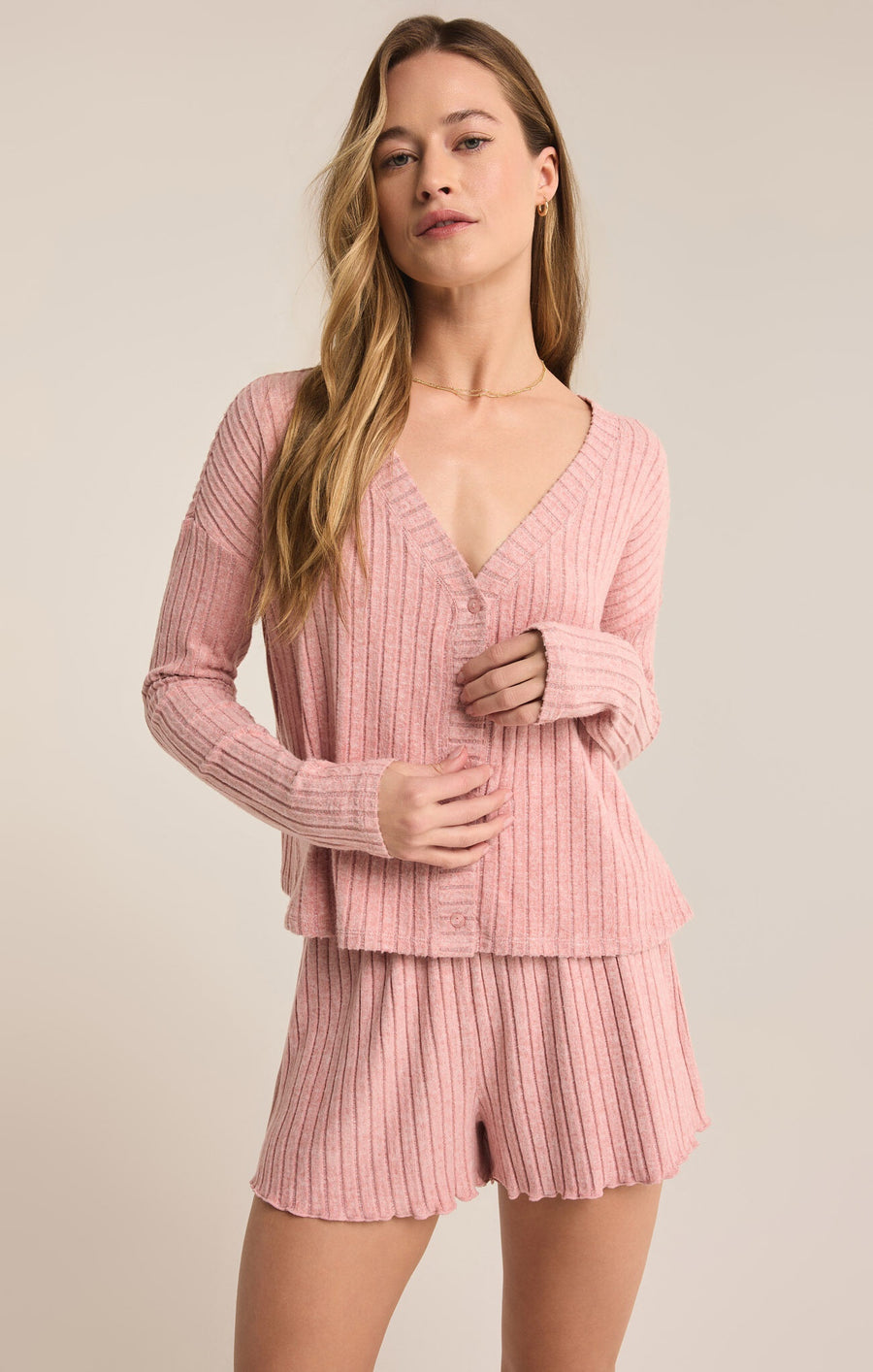 Featuring a ribbed button up long sleeve top in the color rose