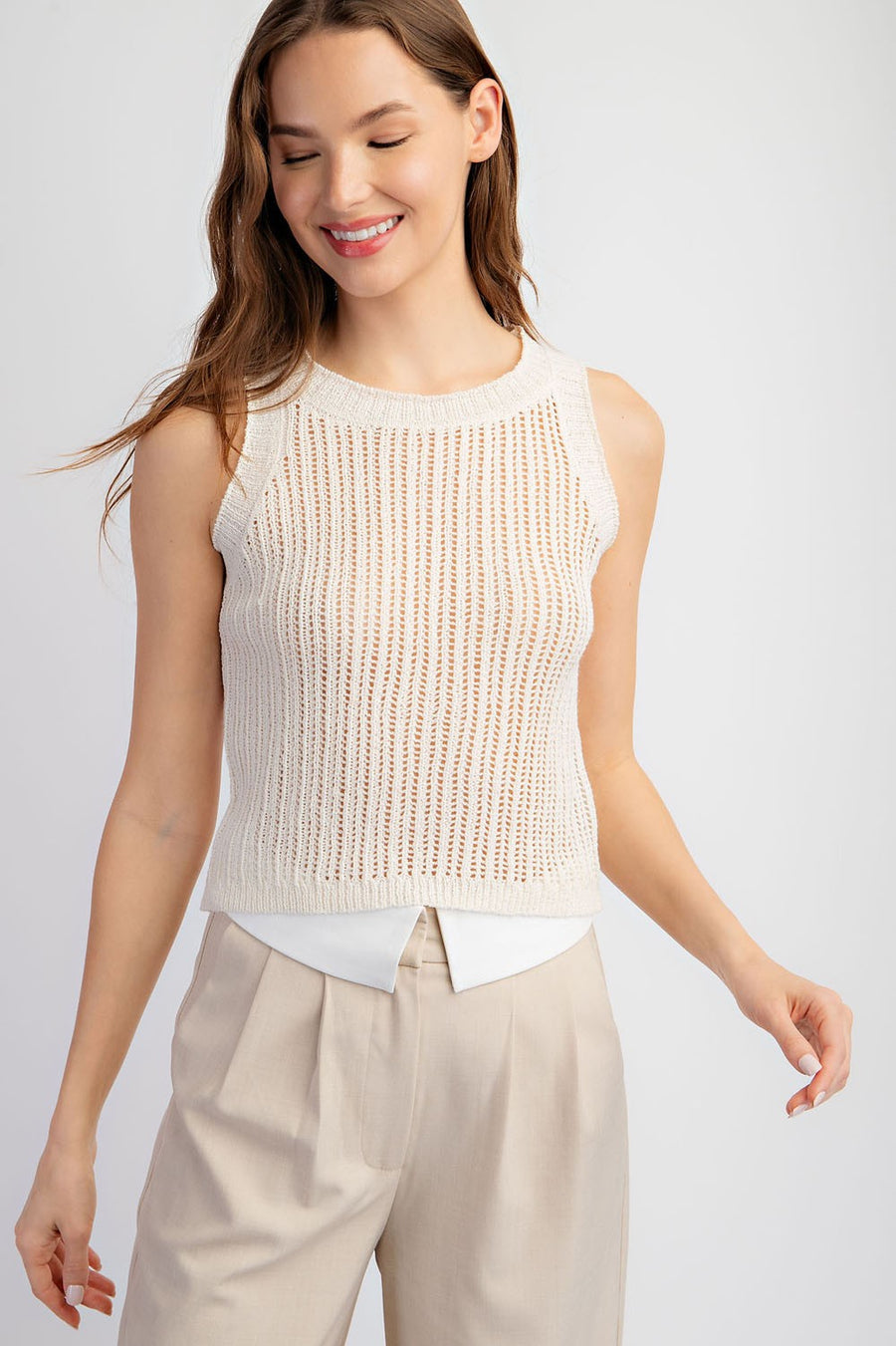 Featuring a sleeveless open knit sweater top