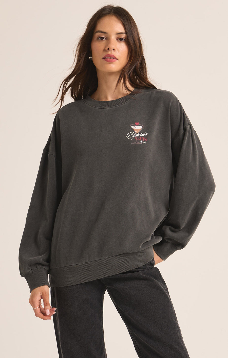 Featuring a relaxed crew neck long sleeve with an esspresso martini graphic print on the front and back in the color black sand 