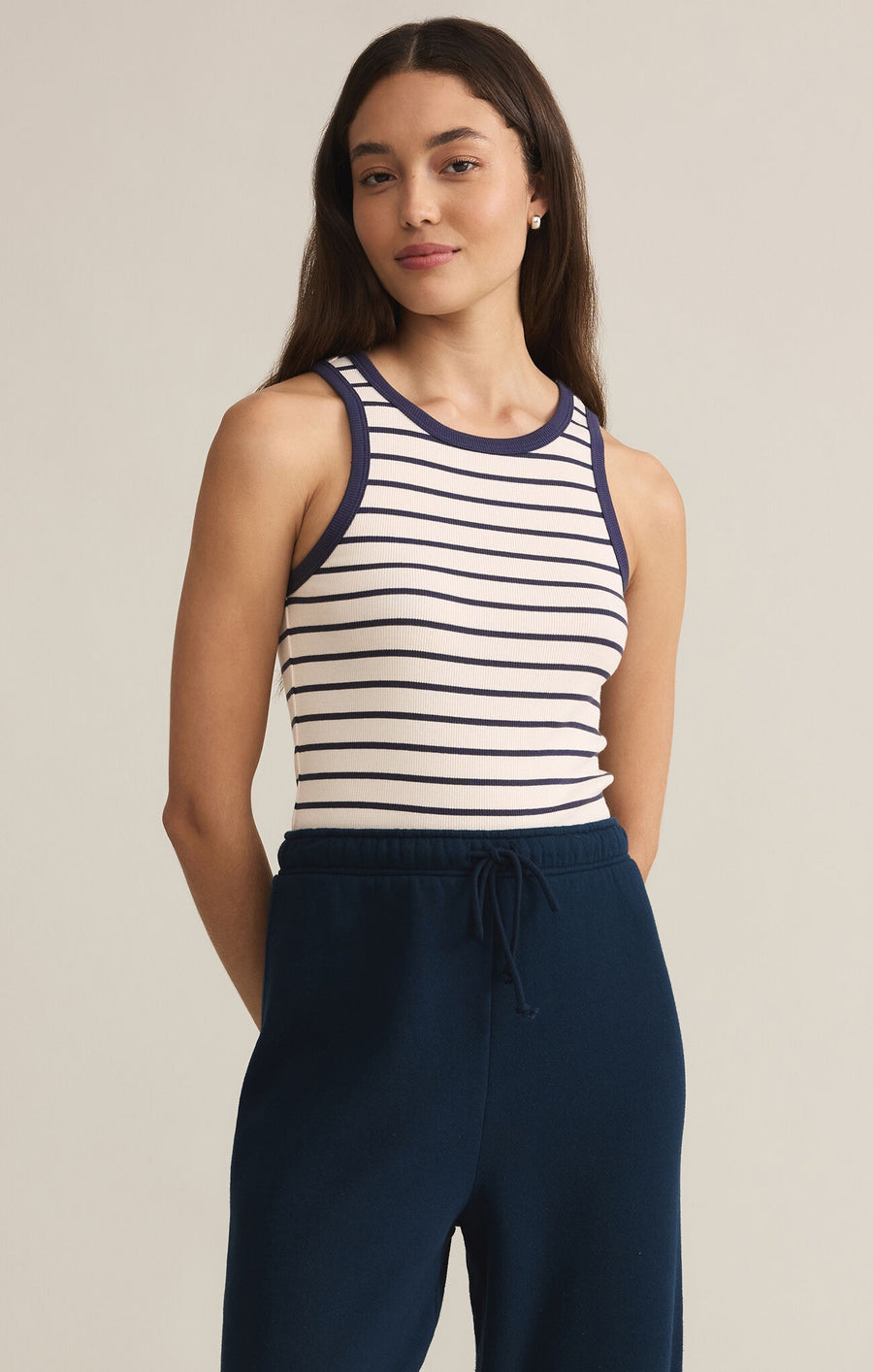 Featuring a sleeveless striped crew neck tank top in the color supernova