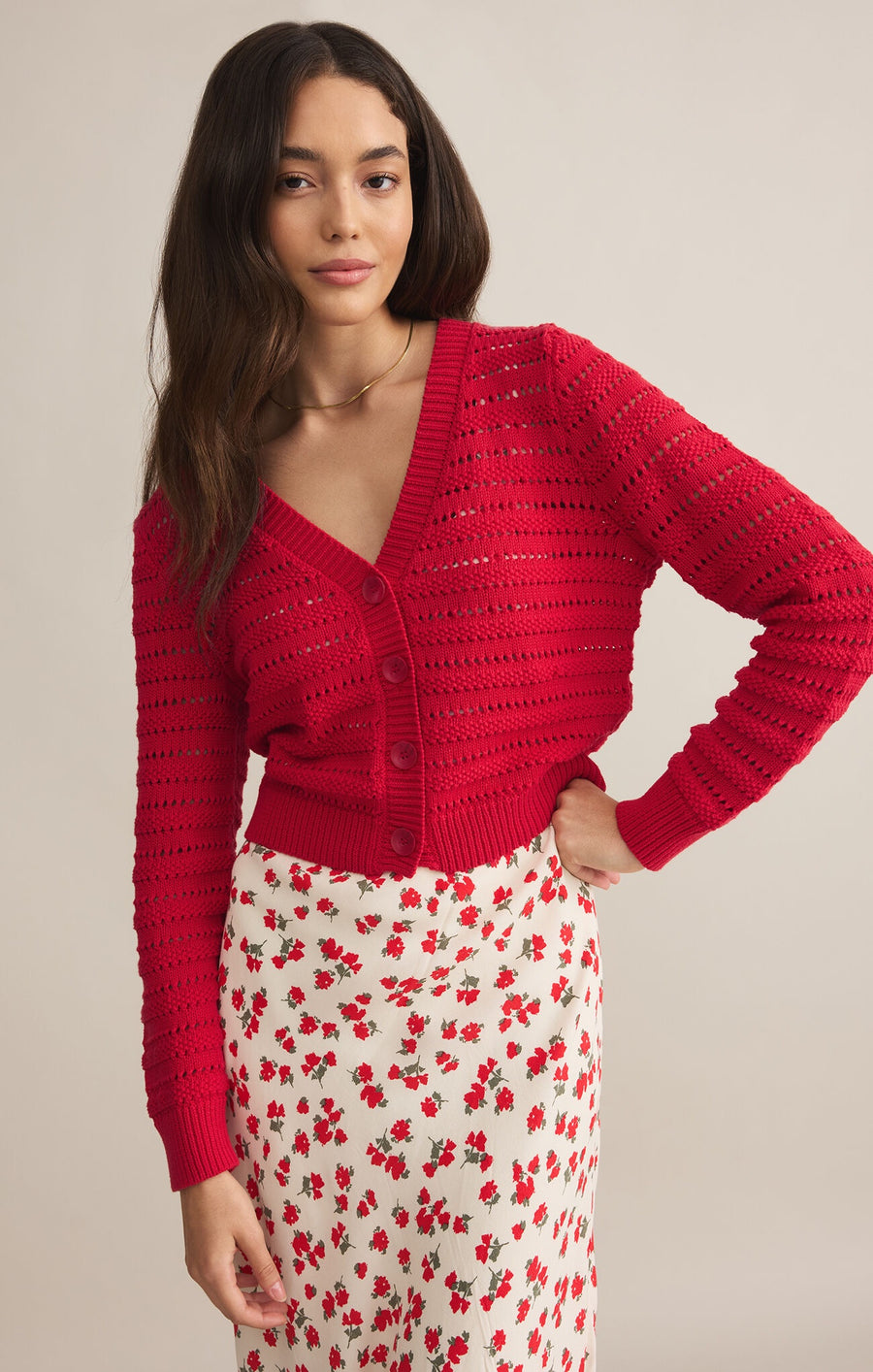 Featuring a loose knit cropped button up cardigan in the color cherry 