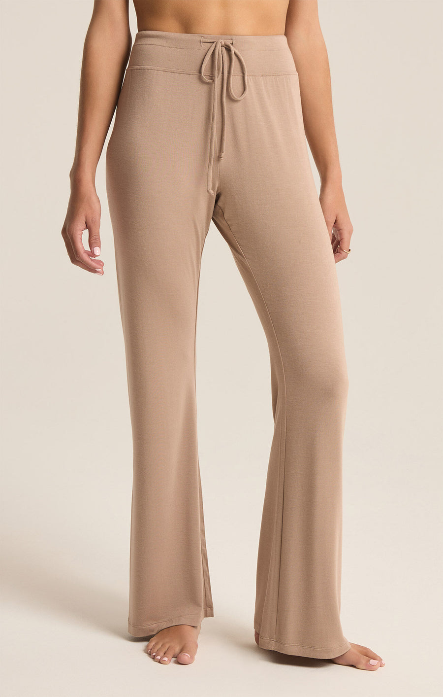 Featuring a flare drawstring pant in the color latte 