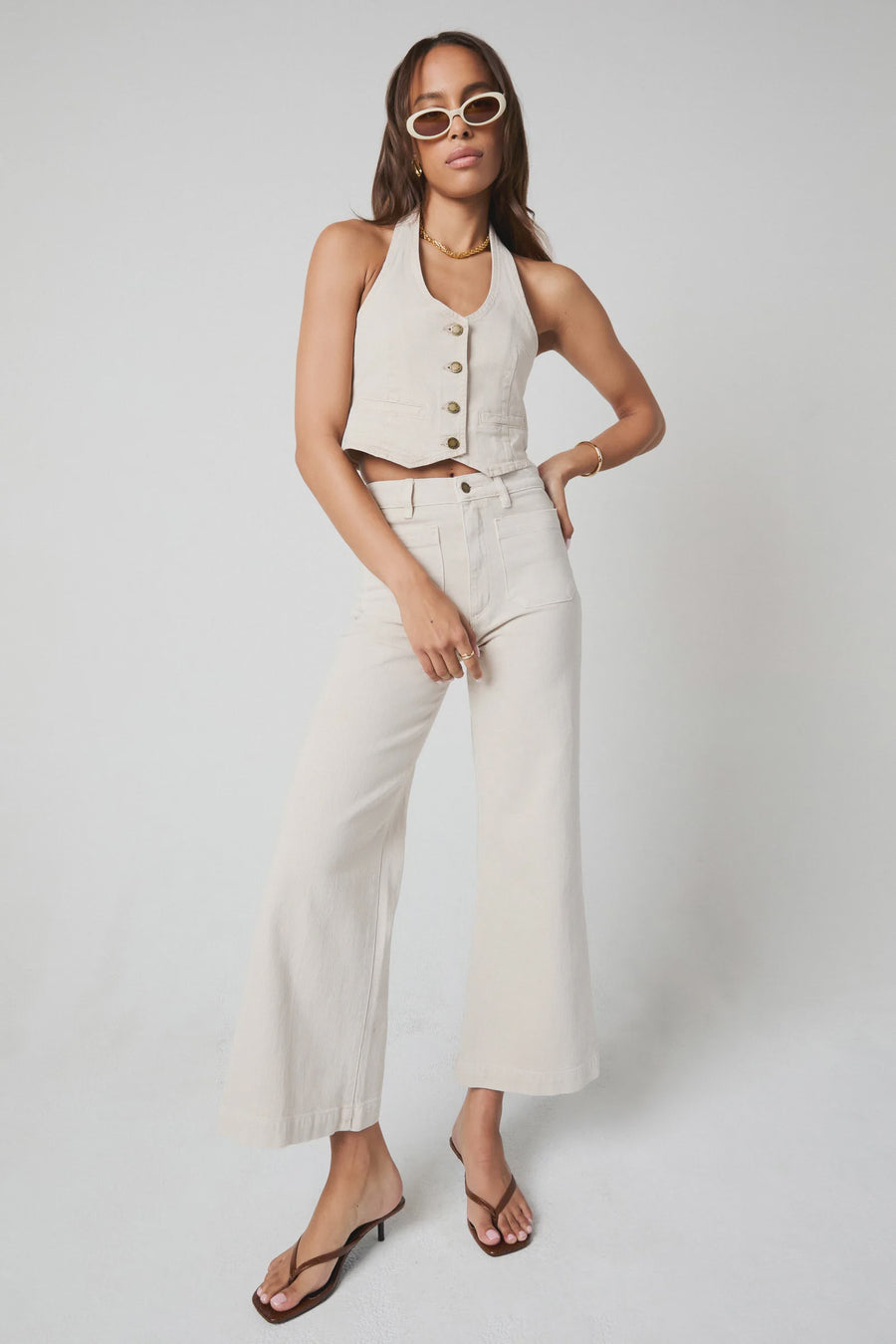 Featuring a cropped wide leg denim pant in the color off white 