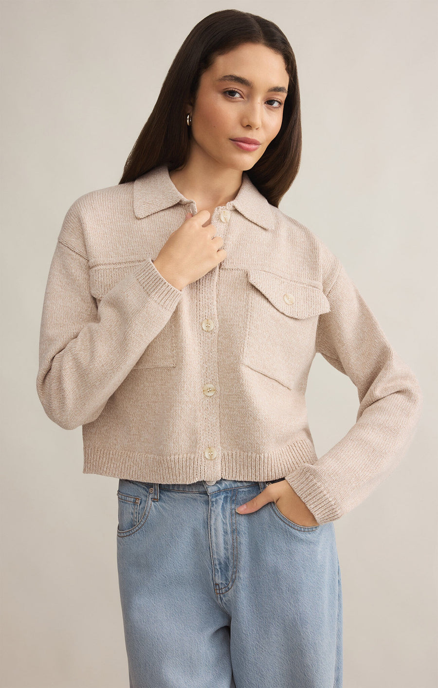 Featuring a cropped long sleeve jacket with patch pockets in the color parchment (beige)