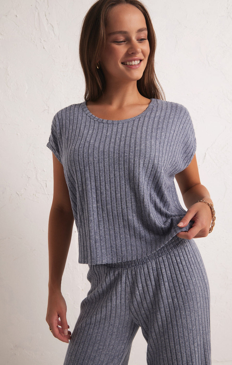 Featuring a ribbed relaxed short sleeve top in the color dusty navy 