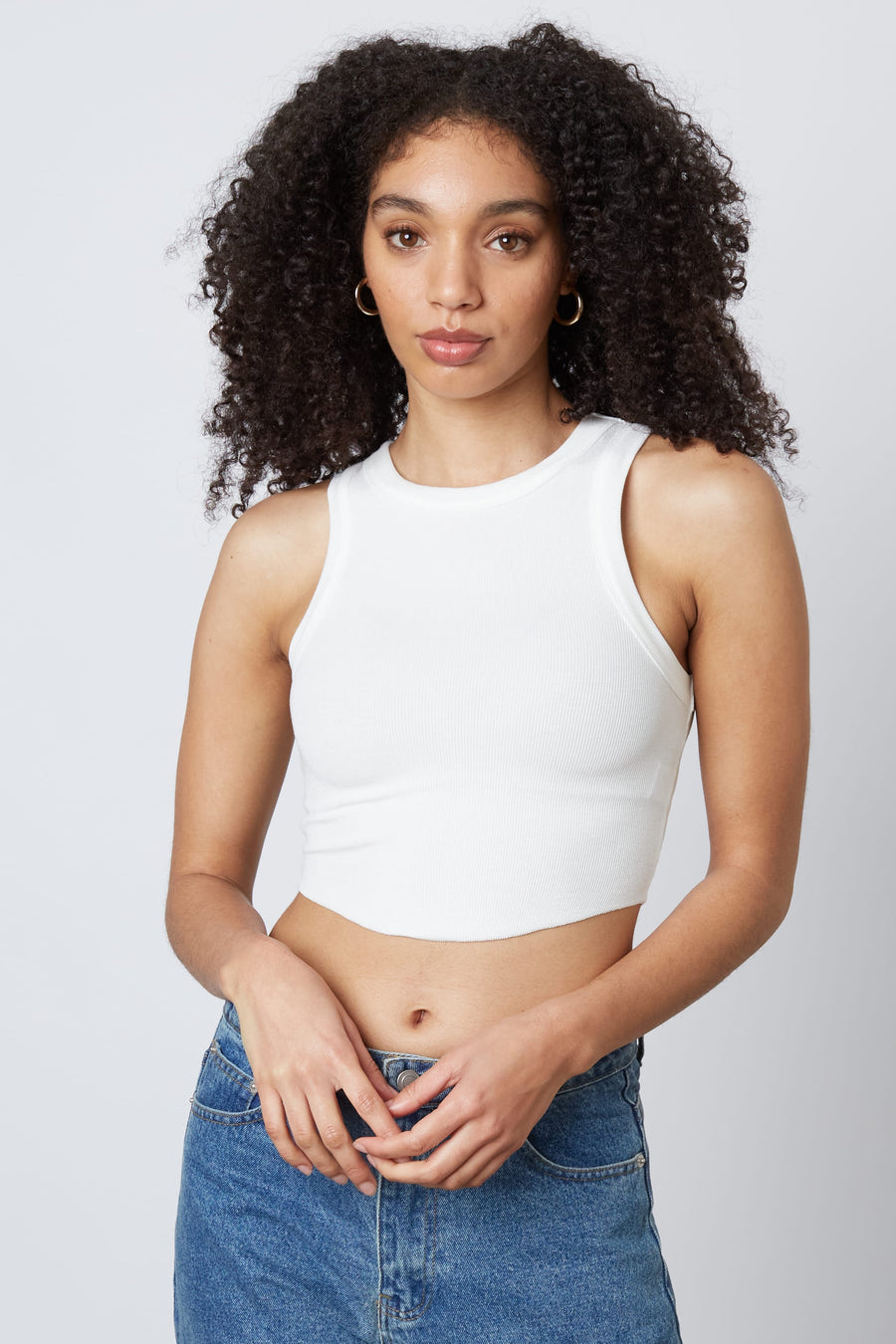 model is wearing a cropped tank top in the color white.