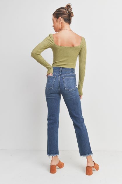 Model is wearing straight leg, dark wash denim jeans.