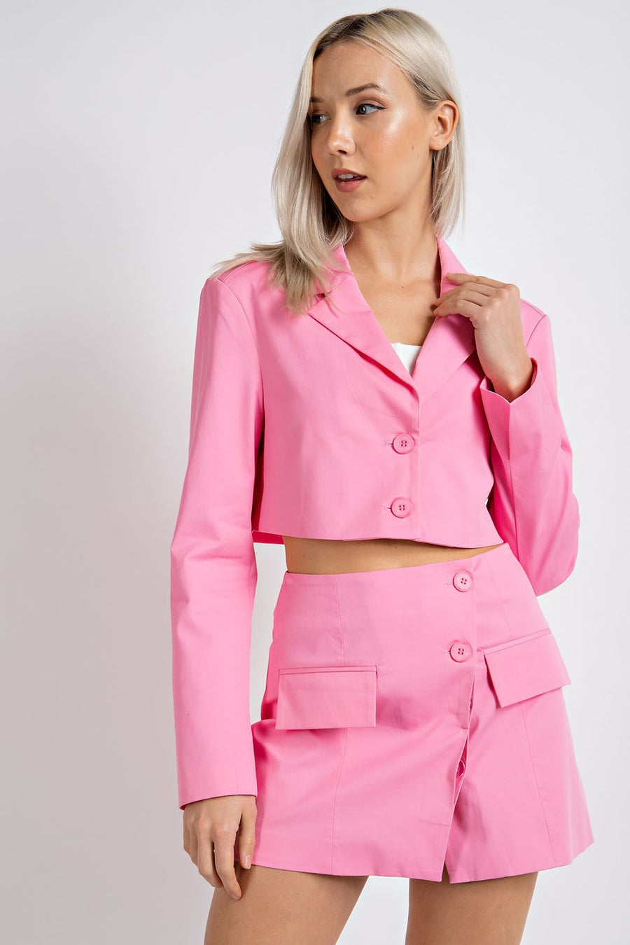Model is wearing a cropped pink blazer.