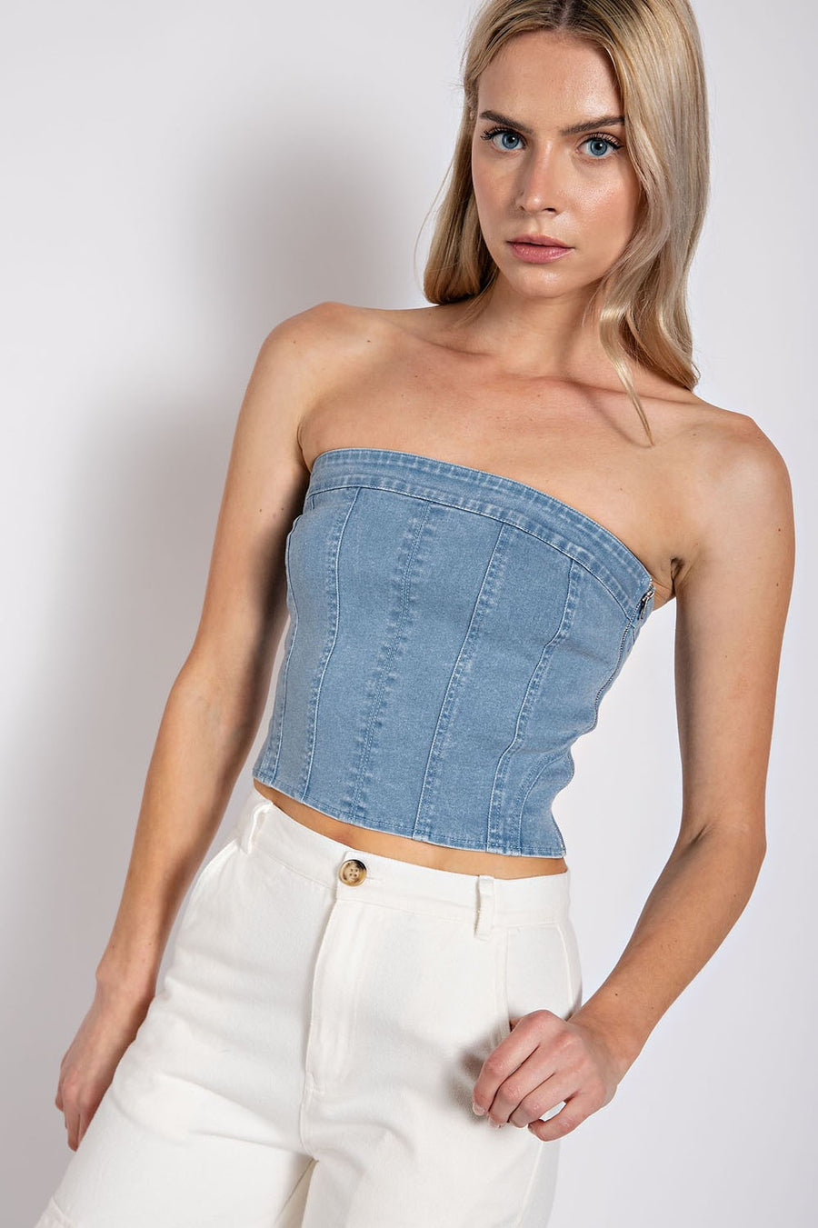 Model is wearing a denim, strapless tube top.