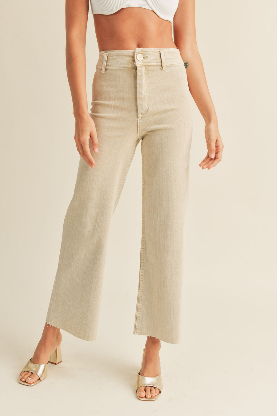Beige cropped pants with belt loops and highwaisted fit. 