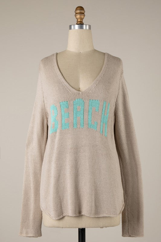 Featuring a ligh weight sweater with the word "Beach" in the front and a wide neckline.