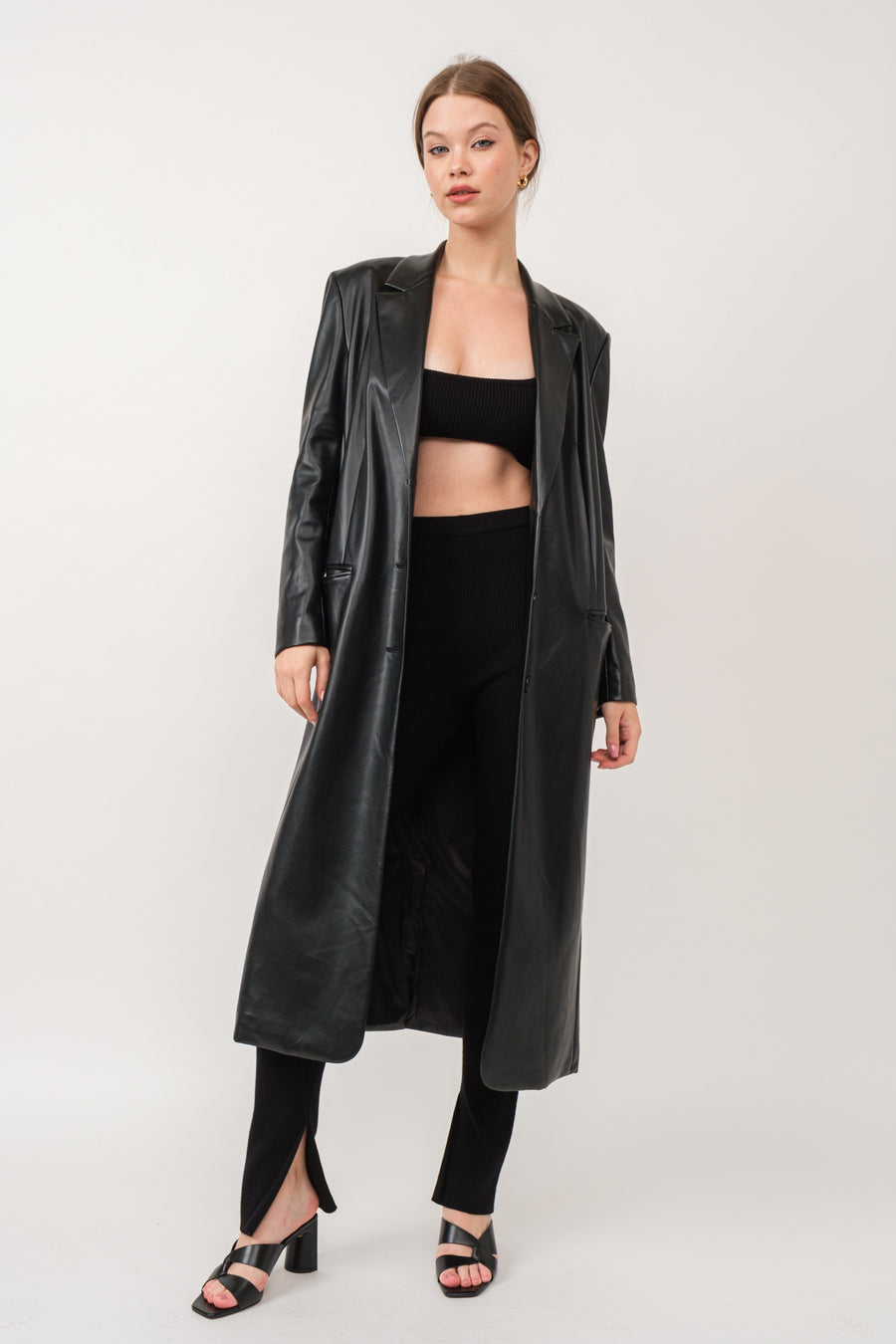 Featuring a long trench with two front buttons and removable shoulder pads in the color black