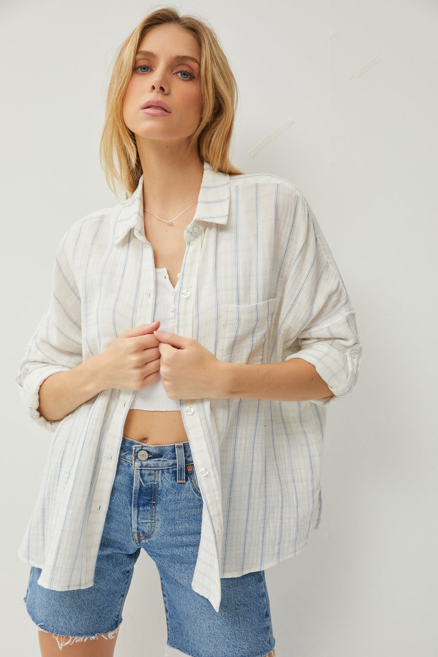 Featuring a relaxed fit button up with double rolled sleeves and a chest pocket detail in the color Ivory/Chambray 