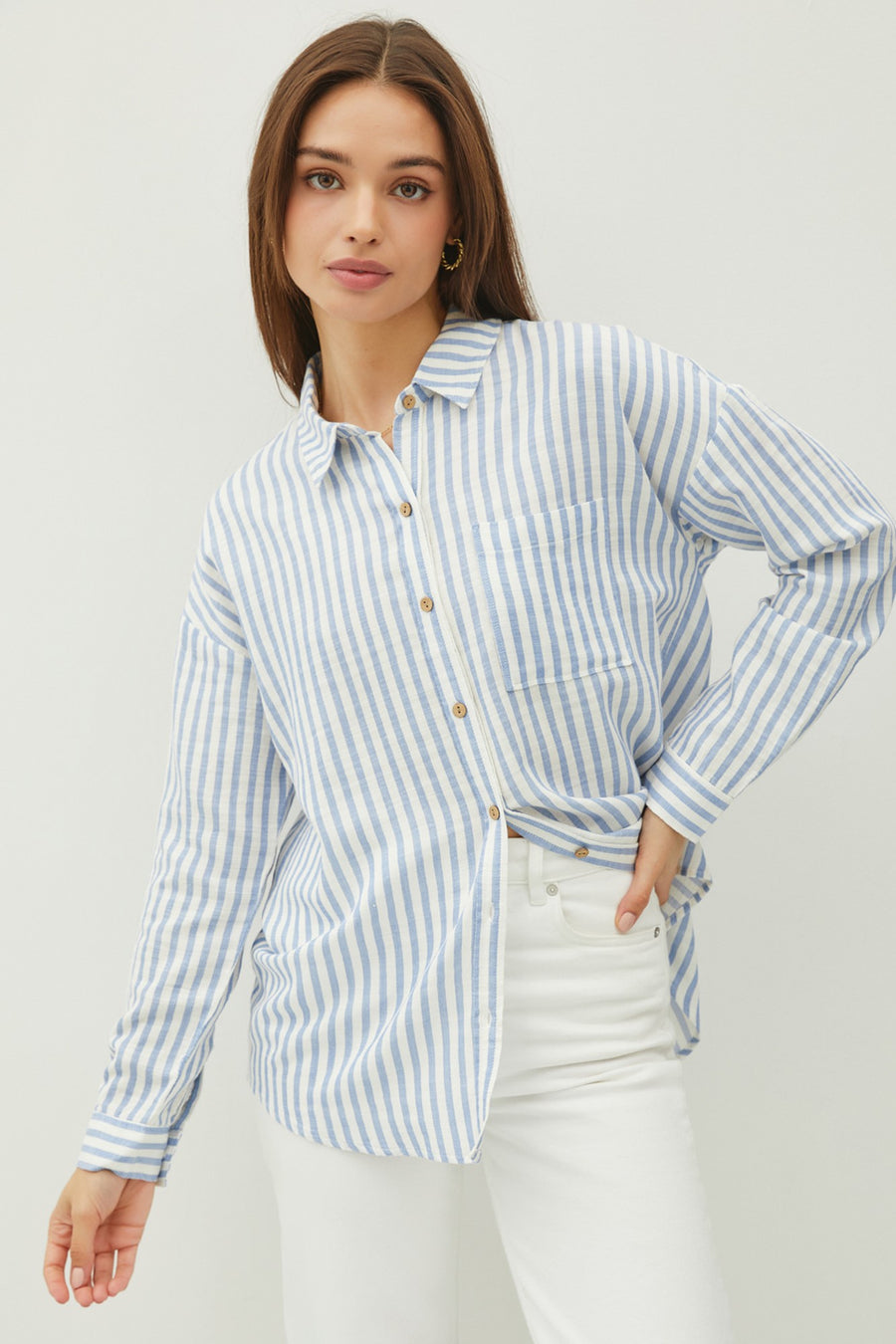 Featuring a fitted longsleeve striped button up with front pocket detail in the color Blue stripe
