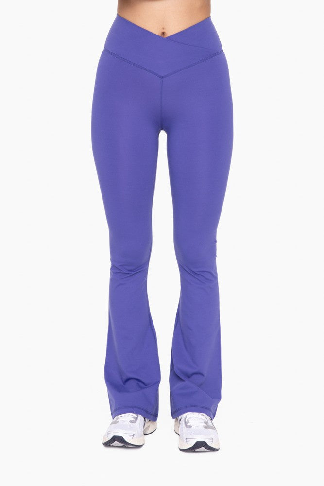 Featuring a high waisted flare yoga pant with a crossover waistband in the color orient blue 
