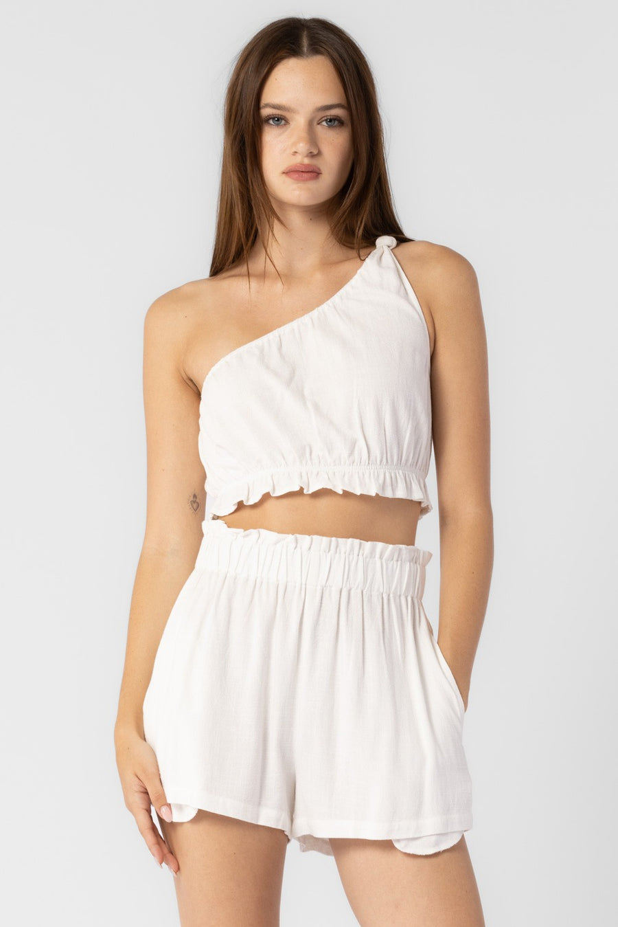 Featuring a one shoulder knot crop top with ruffle detailing. Best paired with the matching Logan Shorts.