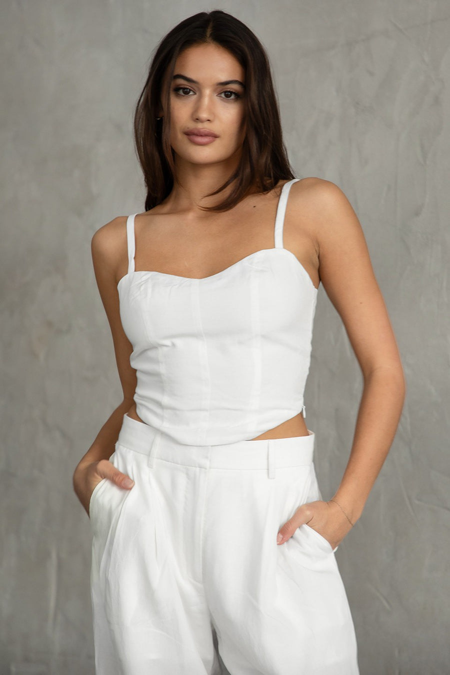 Featuring a cropped fitted tank with a side zipper in the color white 