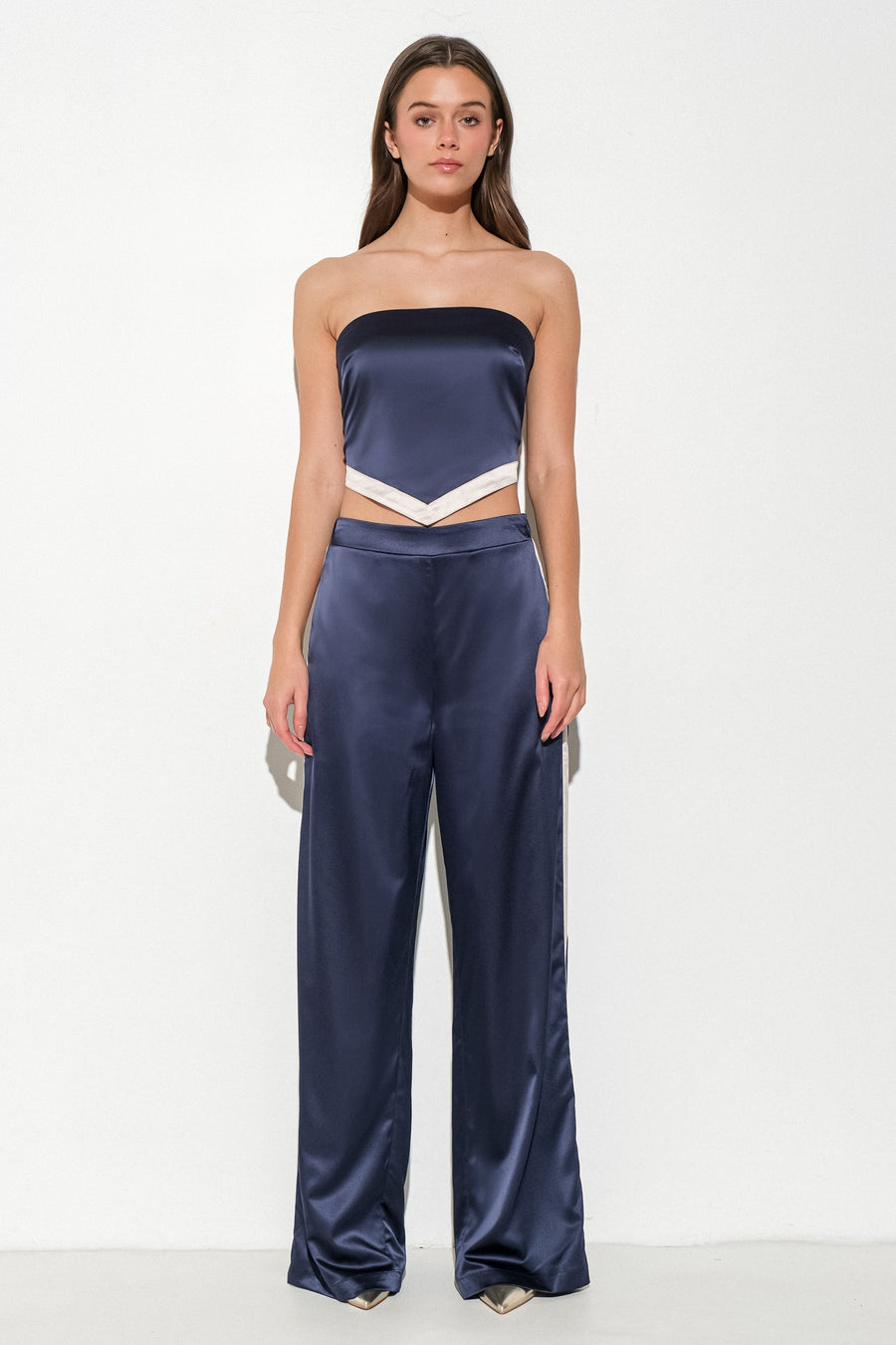 Featuring a loose fit satin pant with a side zipper in the color Navy/Cream