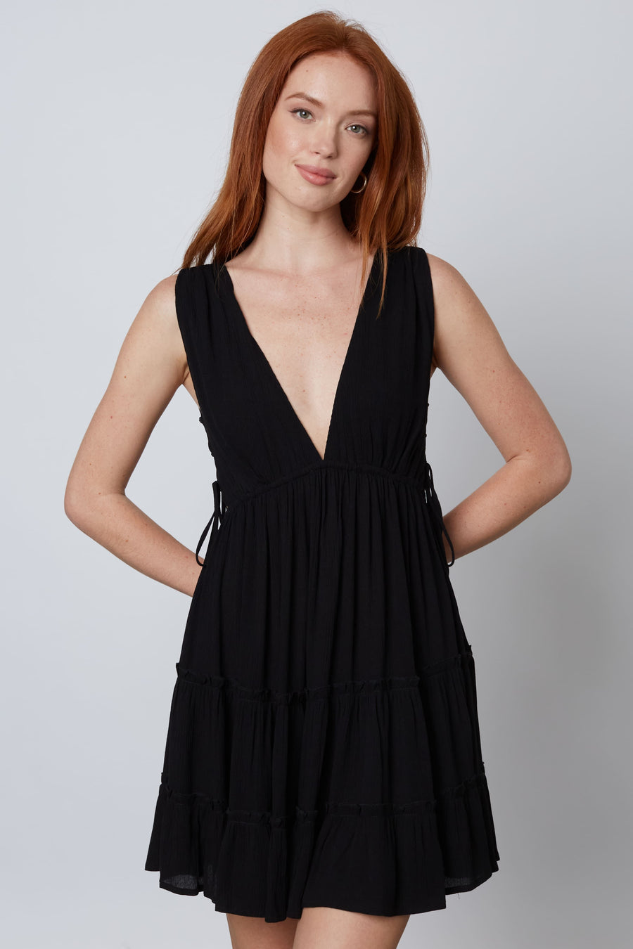 Black ruffle dress with a deep v-neckline with lace up side cut outs.