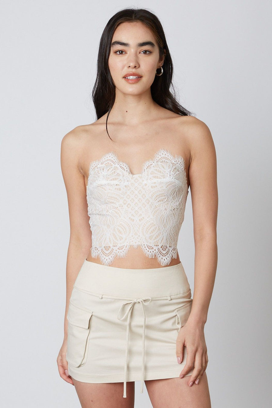 Model is wearing a strapless tube top with lace detail.
