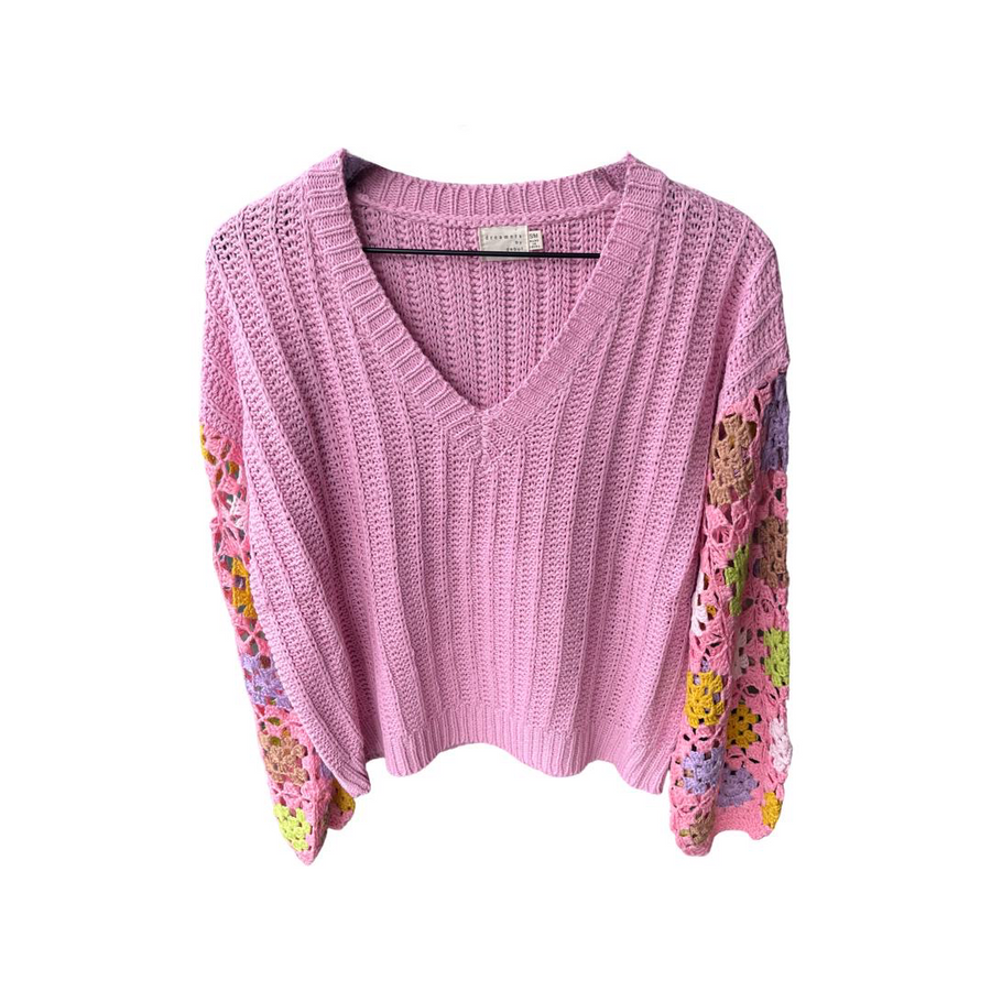 Pink long sleeve sweater. Normal sweater knit material in the chest section of the sweater. Crochet multi-colored pattern with less knit coverage on sleeves. 