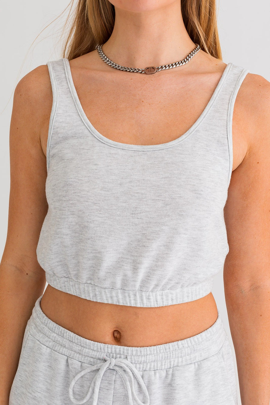 Cropped tank top with waistband in the color heather grey.