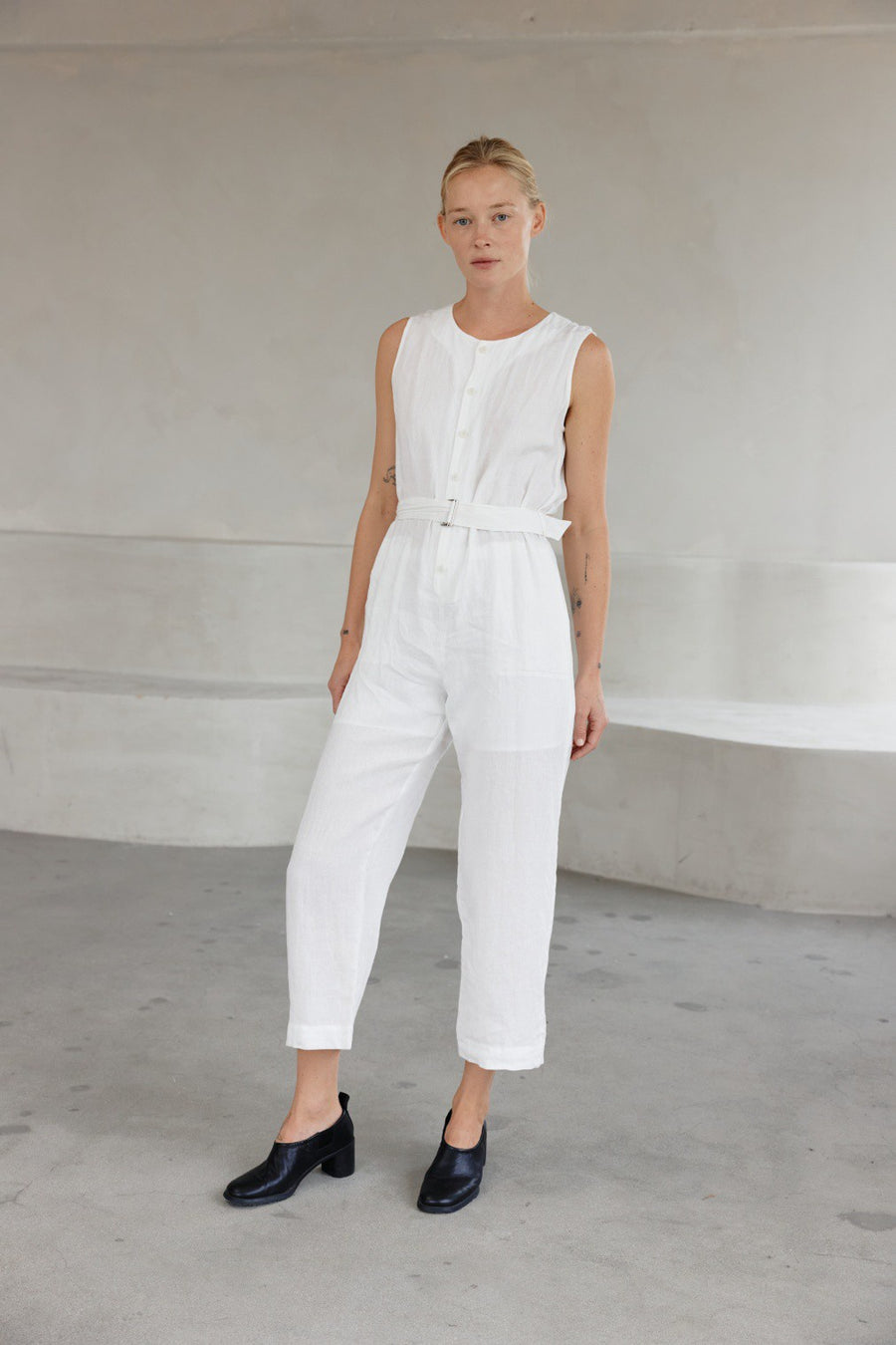 Featuring a linen jumpsuit with a crew neckline, front button detailing and a belt attached