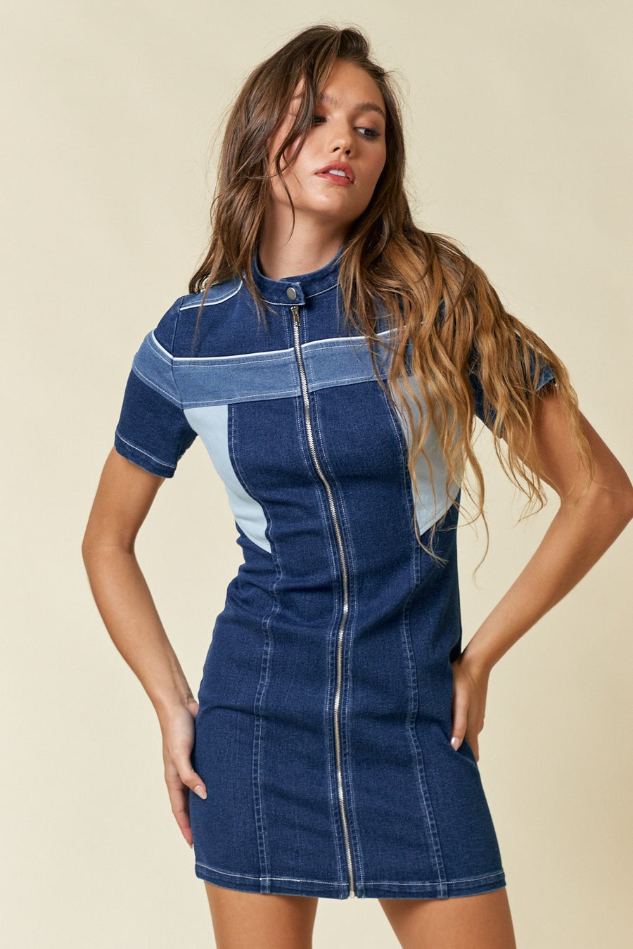 Featuring a moto style denim dress with color blocking and a front zipper.