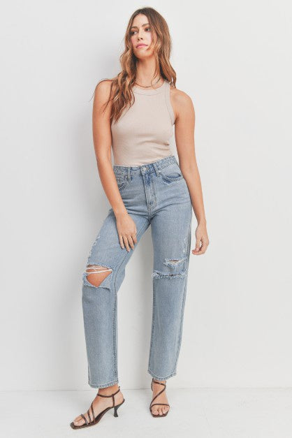 High-waisted, non-stretch denim pants with rips on the knees.