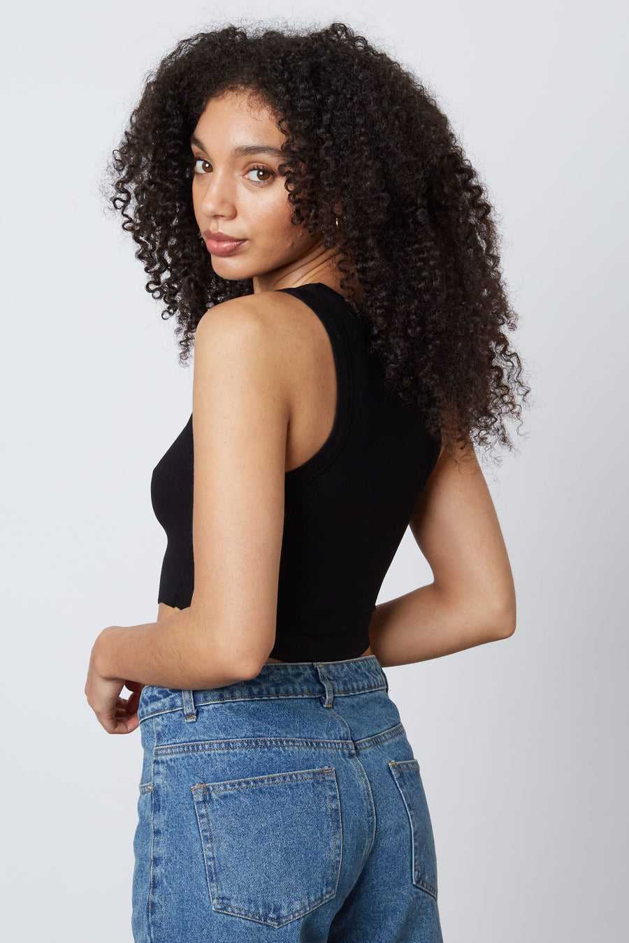 model is wearing a cropped tank top in the color black.