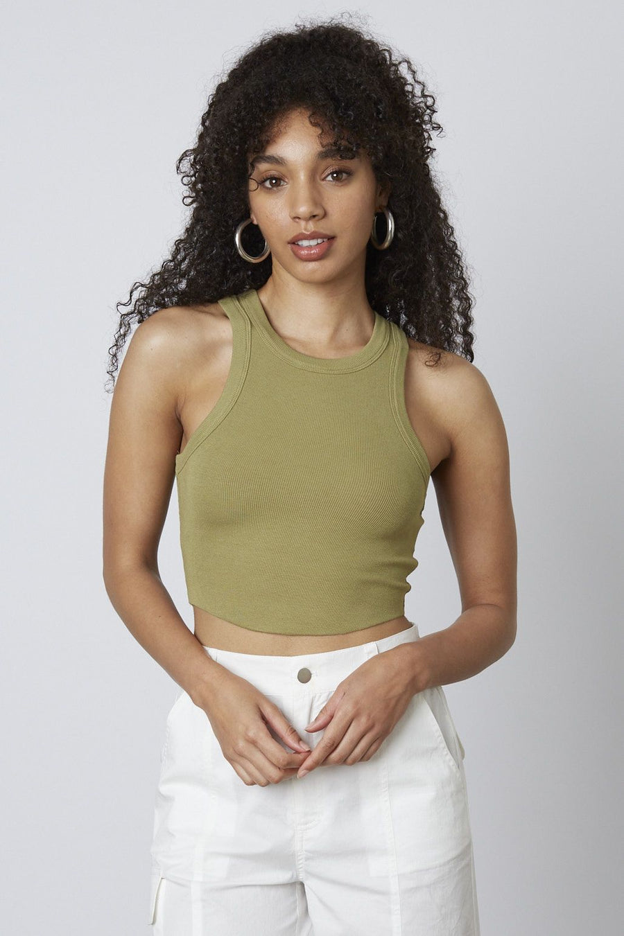 model is wearing a cropped tank top in the color olive.